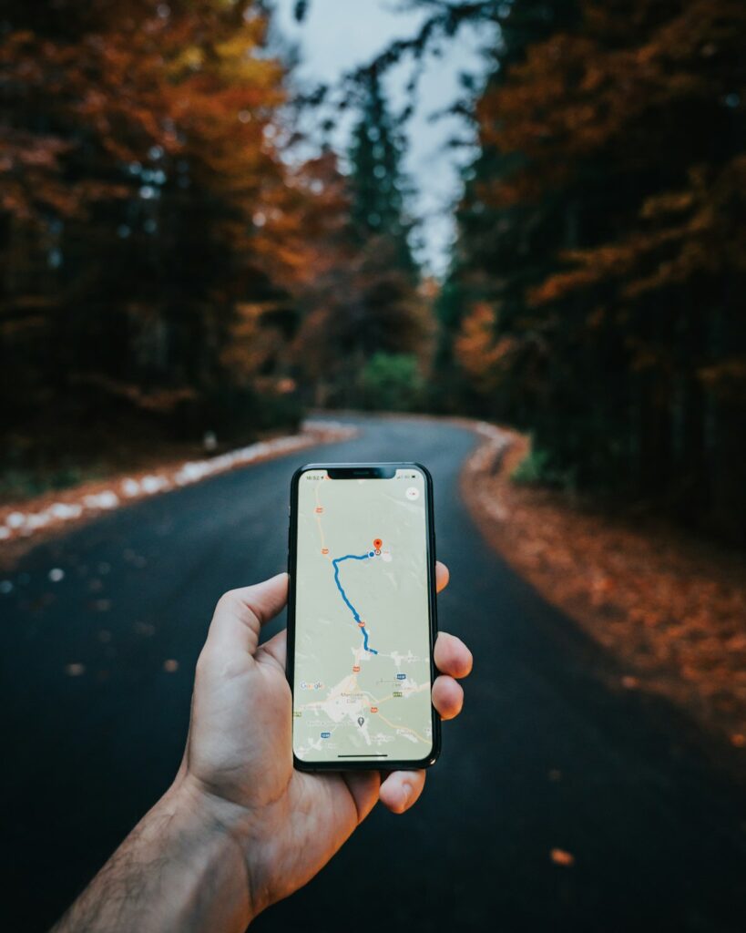 Hand holding a smartphone showing a route on a map app